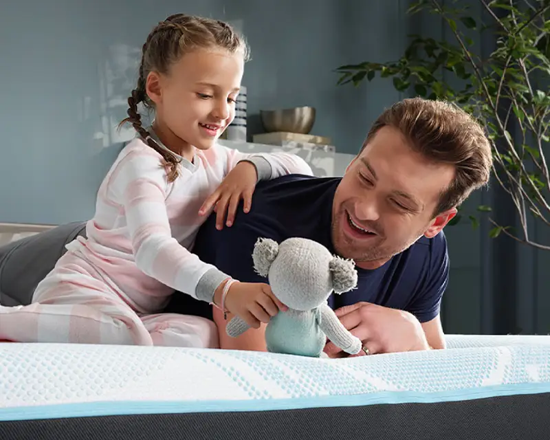father daughter enjoying luxury mattress from Gutzler's Furniture